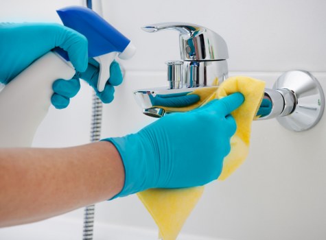 Cleaner applying health and safety measures during a carpet clean