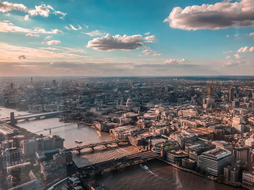 Aerial view of Kingston, showcasing the modern Kingston Centre with its angular and glass-fronted buildings situated along the riverside, surrounded by a mix of residential and commercial structures. 